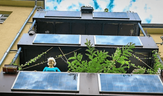 Woman on balcony with solar panels, showcasing sustainable energy in urban living.