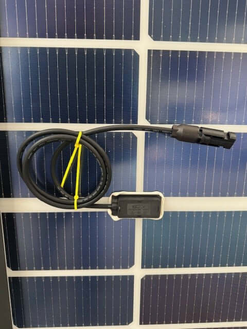 Solar power connector attached to a solar panel, showcasing the integration of solar technology.